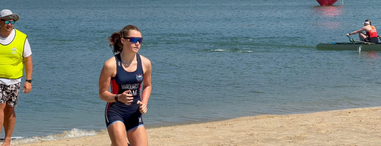 Alia Marquardt sprinting up the beach in the Samoa unisuit during a beach sprint race