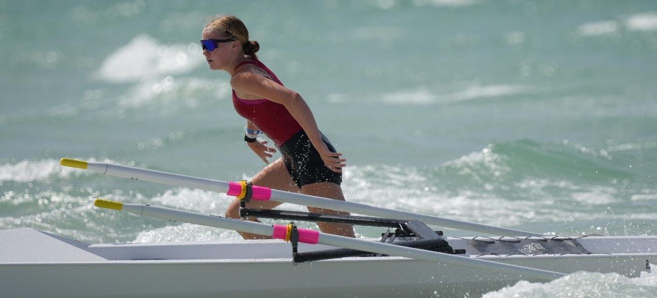 A Beach Sprint racer leaps from a coastal boat into the surf at the finish