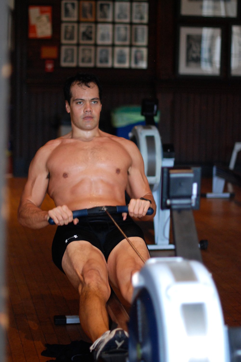 Daniel Marquardt mid-drive on a Concept2 ergometer in a boathouse erg room